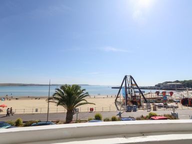 A beach view with a playground in the foreground at The Beach Condo in Weymouth