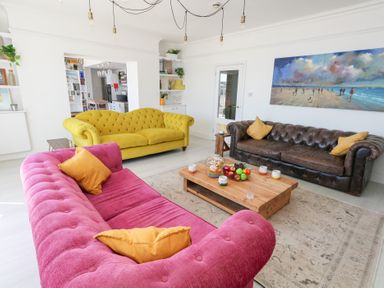 A living room with colorful sofas and a coffee table at The Beach Condo in Weymouth