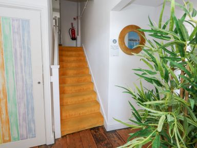 A hallway with a staircase and door at The Beach Condo in Weymouth