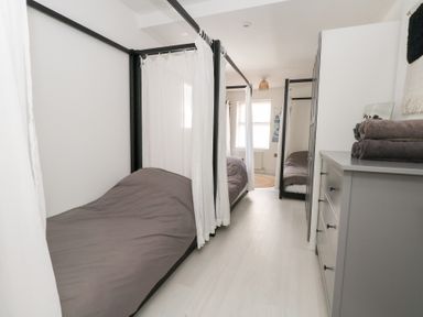 A bedroom with two beds and a cabinet at The Beach Condo in Weymouth