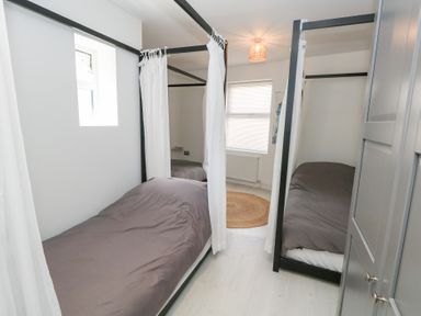 A bedroom with two single beds and a window at The Beach Condo in Weymouth