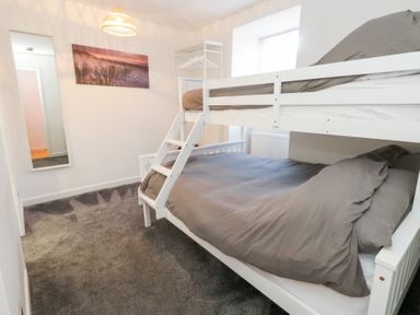 A bedroom with a bunk bed and a mirror at The Beach Condo in Weymouth