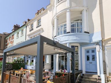 An outdoor seating area in front of a building at The Beach Condo in Weymouth