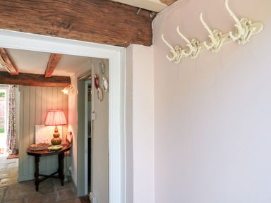 An entryway with a lamp and table at Old Farm Cottage in Warminster