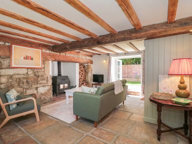 A living room with a fireplace and sofa at Old Farm Cottage Warminster