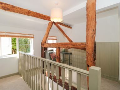 A landing with wooden beams and a glass table at Old Farm Cottage Warminster