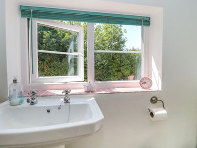 A bathroom with a sink and window at Old Farm Cottage in Warminster