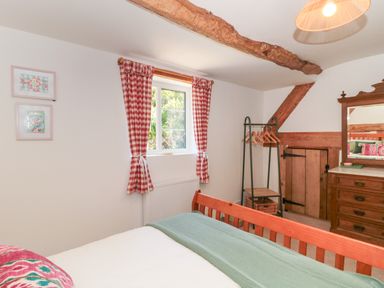 A bedroom with a bed and wardrobe at Old Farm Cottage in Warminster