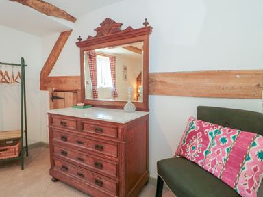 A bedroom with a dresser and mirror at Old Farm Cottage in Warminster