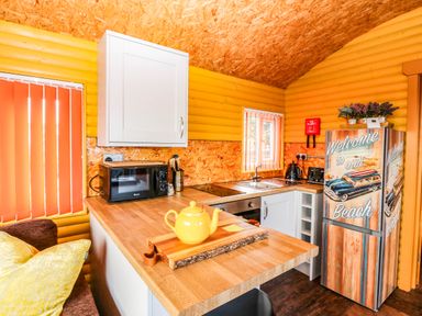 A kitchen with a countertop, sink, microwave and refrigerator at Ava Lodge West Mains near Haggerston