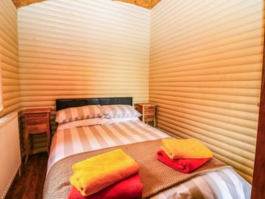 A bedroom with a bed and side tables at Ava Lodge West Mains near Haggerston