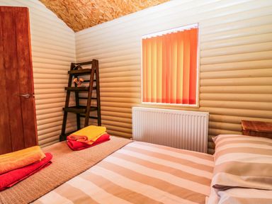 A bedroom with a bed and shelf at Ava Lodge West Mains near Haggerston