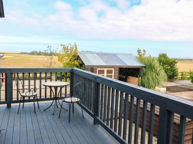 An outdoor area with a table and chairs at Ava Lodge in West Mains near Haggerston