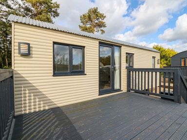 A cabin exterior with a deck at Masons Hut in West Mains near Haggerston