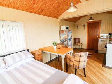 A studio with a bed and a table at Masons Hut in West Mains near Haggerston