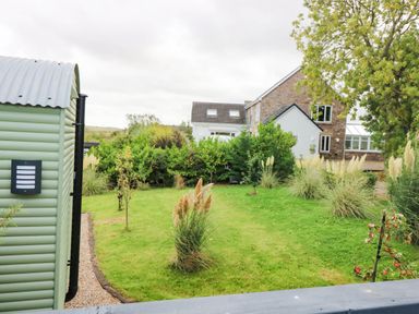 A garden with a shed and plants at Masons Hut in West Mains near Haggerston