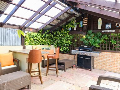 An outdoor kitchen with a barbecue grill and seating at Masons Hut near Haggerston