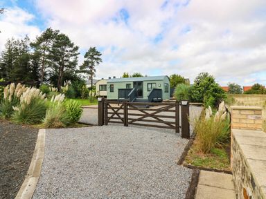 An outdoor view of a caravan and gate at Masons Hut West Mains near Haggerston