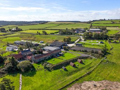An aerial view of farmland with houses and barns at Mini pod in Staintondale near Burniston
