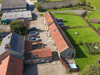 An outdoor view of vehicles and buildings at Mini pod Staintondale near Burniston