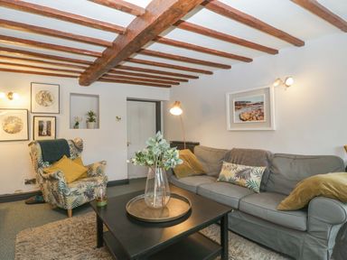 A living room with a sofa and armchair at Elm Cottage in Moreton-In-Marsh