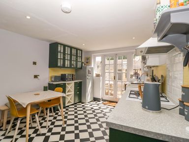 A kitchen with a table and chairs at Elm Cottage in Moreton-In-Marsh