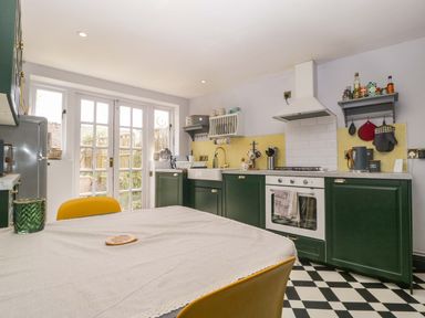 A kitchen with a table and chairs at Elm Cottage in Moreton-In-Marsh