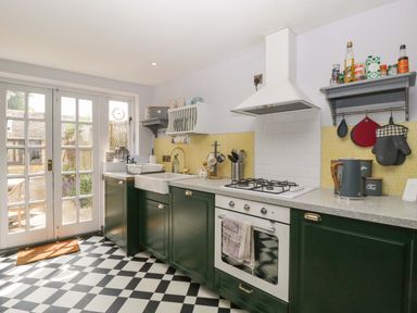 A kitchen with a sink and stove at Elm Cottage in Moreton-In-Marsh