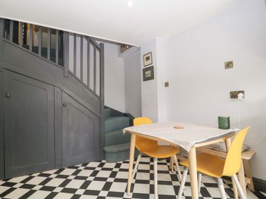 A dining room with a table and yellow chairs at Elm Cottage Moreton-In-Marsh