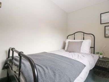 A bedroom with a bed and nightstand at Elm Cottage Moreton-In-Marsh
