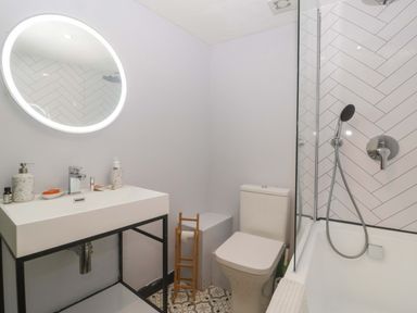 A bathroom with a sink, toilet, and shower at Elm Cottage in Moreton-In-Marsh