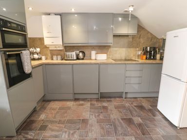 A kitchen with appliances and cabinets at The Cottage in St. Ives