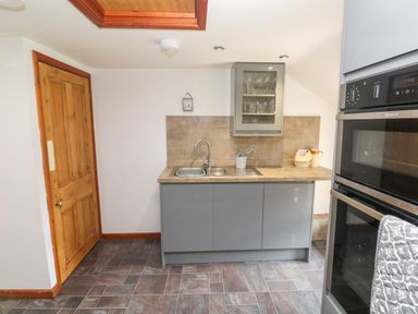 A kitchen with cabinets and appliances at The Cottage in St. Ives