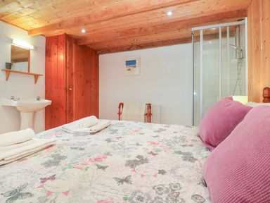 A bedroom with a bed and a sink at The Cottage in St. Ives