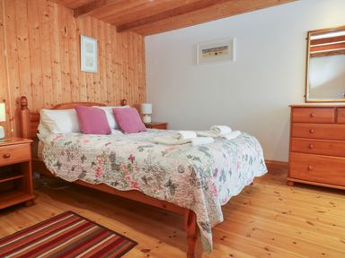 A bedroom with a bed and dresser at The Cottage St. Ives