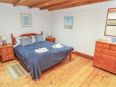 A bedroom with a bed and nightstands at The Cottage, St. Ives