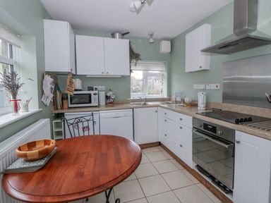 A kitchen with appliances and a table at Yr Hen Ysgoldy