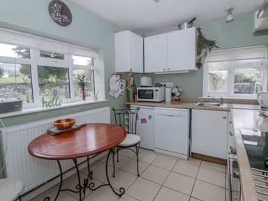 A kitchen with a table and chairs at Yr Hen Ysgoldy in 