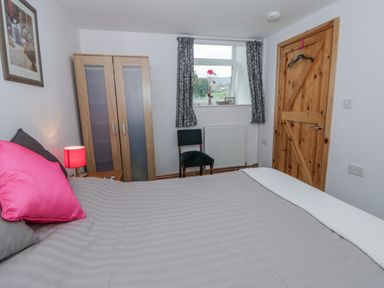 A bedroom with a bed and wardrobe at Yr Hen Ysgoldy
