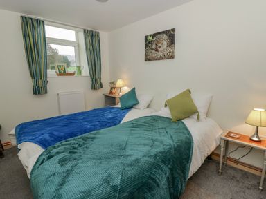 A bedroom with two beds and a window at Yr Hen Ysgoldy