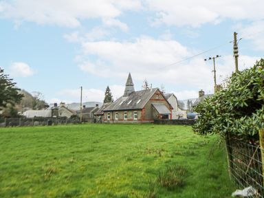 A house surrounded by grass and trees at Yr Hen Ysgoldy in 