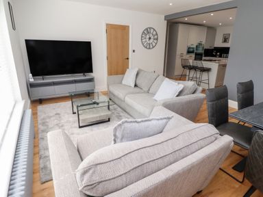 A living room with a television and sofa at Rose Cottage in Dunstan near Embleton