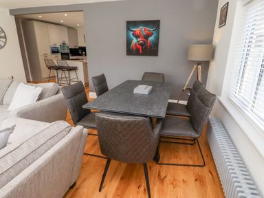 A dining room with a table and chairs at Rose Cottage Dunstan near Embleton