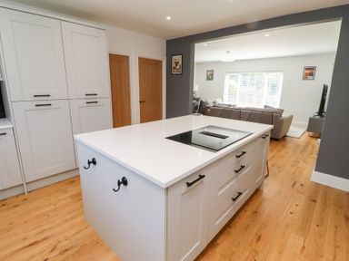 A kitchen with an island and stove at Rose Cottage Dunstan near Embleton