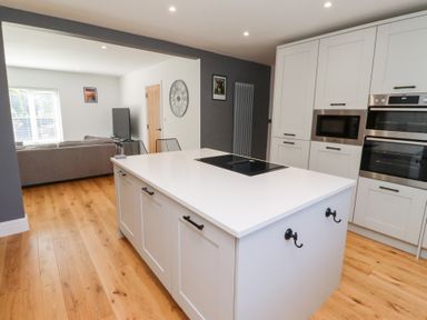 A kitchen with an island and appliances at Rose Cottage in Dunstan near Embleton