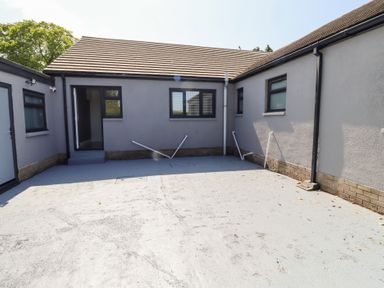 An outdoor area with a building and windows at Rose Cottage in Dunstan near Embleton