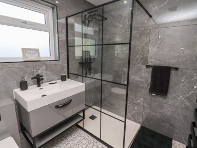 A bathroom with a shower and wash basin at Rose Cottage in Dunstan near Embleton