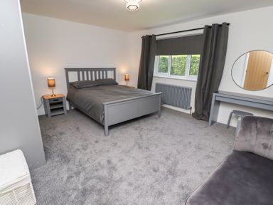 A bedroom with a bed and nightstand at Rose Cottage in Dunstan near Embleton