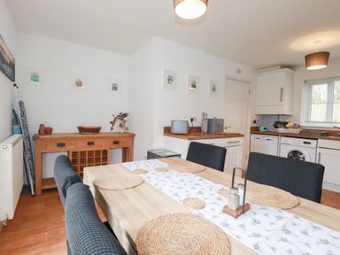 A kitchen with a dining table and chairs at Poldam in St Austell