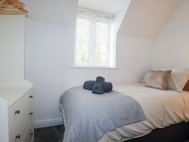 A bedroom with a bed and dresser at Poldam St Austell